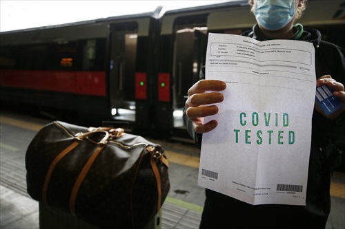 Un pasajero muestra el certificado covid en una estación de tren de Roma, en Italia