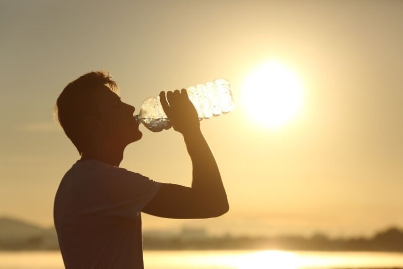 Un hombre bebe agua en un día con altas temperaturas