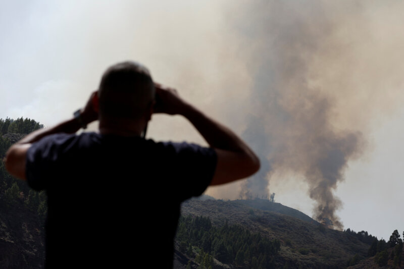 Una persona observa la columna de humo del incendio de Tejeda. Es visible desde diferentes puntos de Gran Canaria / Reuters / Borja Suárez