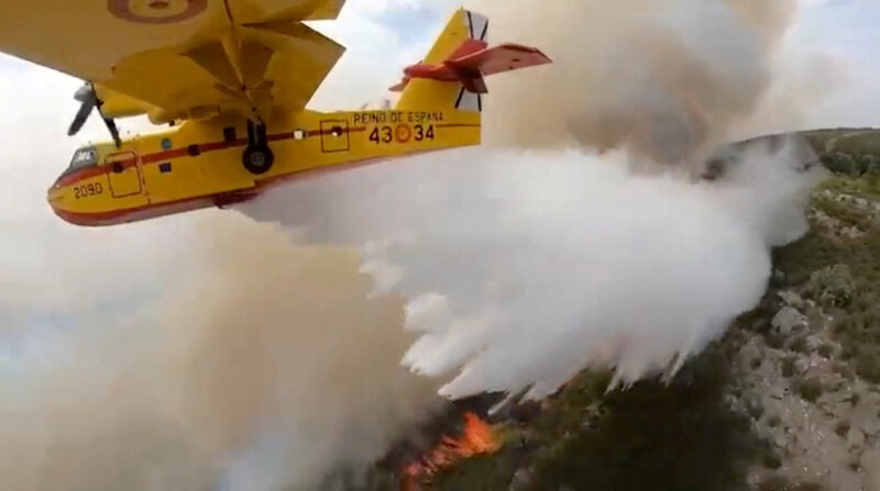 Un avión de extinción de incendios vierte agua sobre la vegetación en llamas durante un incendio forestal de Tenerife. Captura de pantalla tomada de un video publicado el 17 de agosto de 2023 por el Ministerio de Transición Ecológica a través de REUTERS