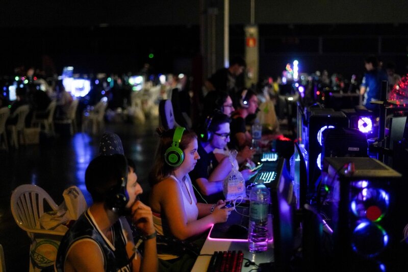 Un grupo de personas juega a videojuegos en una feria