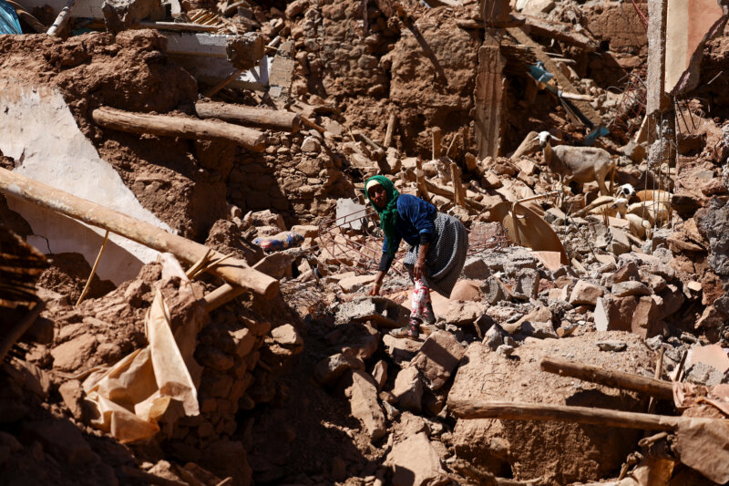 Una mujer camina entre los escombros, junto a una cabra, donde una vez estuvo su casa, mientras intenta rescatar a su cabra después del mortal terremoto en Tinmel, Marruecos, el 11 de septiembre de 2023. REUTERS/Hannah McKay