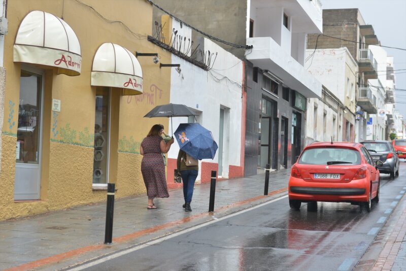 Dos personas pasean bajo la lluvia con un paragua en la mano en Canarias