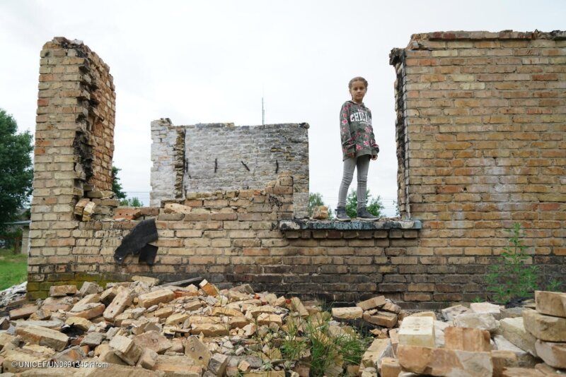 Una niña sobre los escombros de una escuela destruida en Horenka, Ucrania
