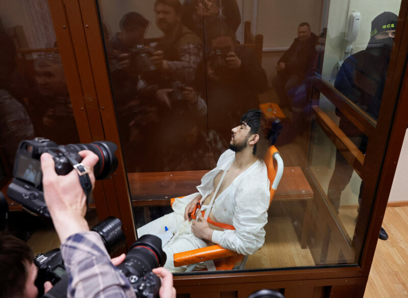 Muhammadsobir Fayzov, sospechoso del ataque a tiros en la sala de conciertos Crocus City Hall, se sienta en una silla de transporte médico detrás de un cristal en un recinto para los acusados ​​antes de una audiencia judicial en el tribunal de distrito de Basmanny en Moscú, Rusia, el 25 de marzo de 2024. REUTERS/Shamil Zhumatov