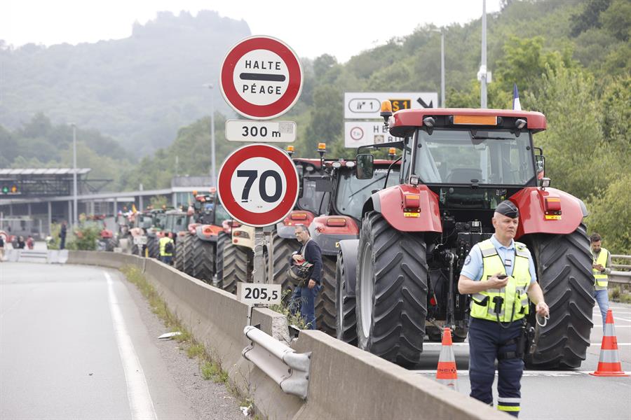 La policía francesa junto a un grupo de agricultores españoles en la frontera con Francia. Imagen EFE