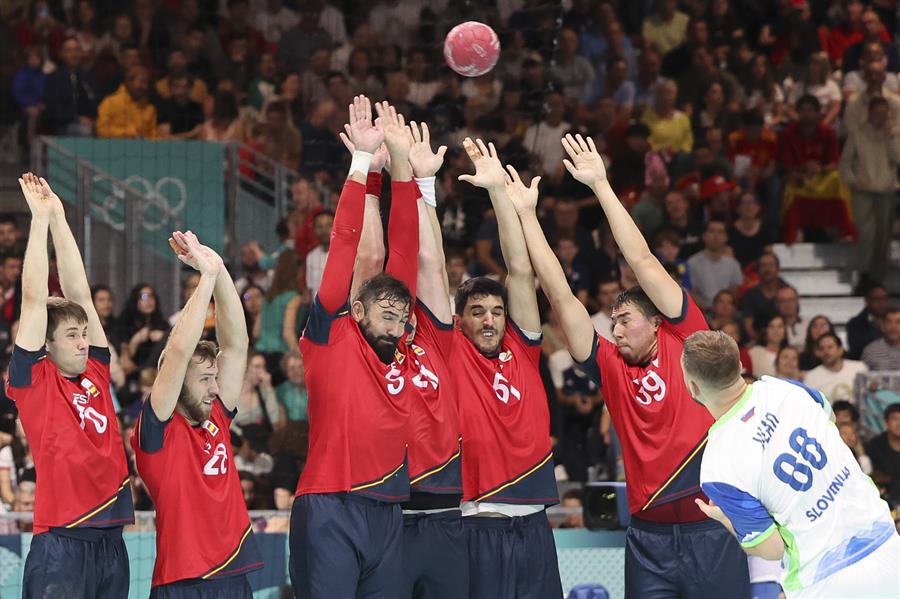 Jugadores del equipo español de balonmano intentan bloquear un tiro del esloveno Aleks Vlah (d) durante el partido de balonmano entre España y Eslovaquia en la fase preliminar de los Juegos Olímpicos París 2024, este sábado, en París, Francia. EFE/ Miguel Gutiérrez