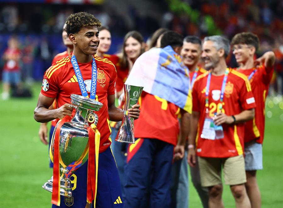 La bandera canaria ha estado sobre el terreno de juego de la final de la Eurocopa 2024 en la celebración de España. Ayoze es uno de los dos canarios junto a Pedri que han ayudado al triunfo de la Selección. En la imagen en primer término Lamine Jamal con la copa y detrás Ayoze con la bandera canaria / EFE 