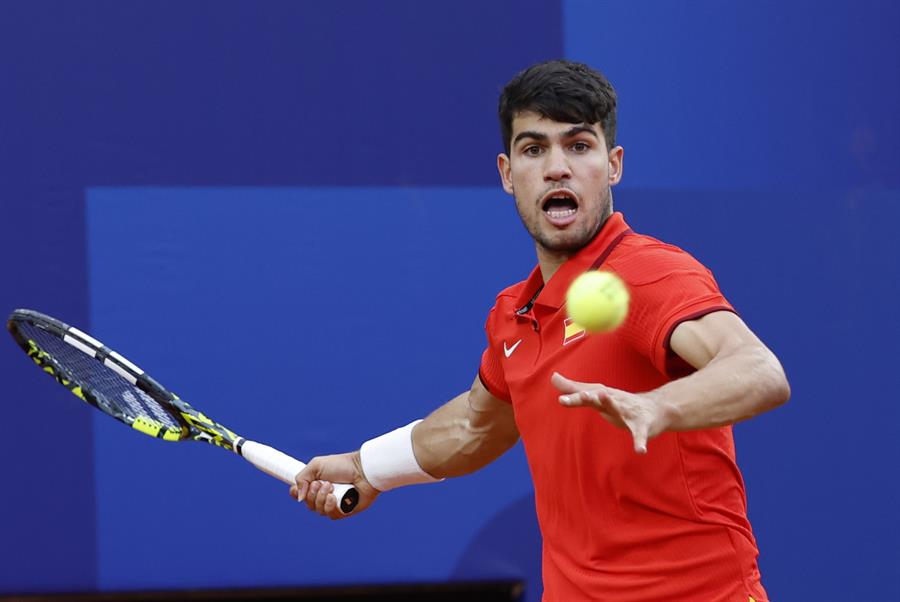 El tenista español Carlos Alcaraz devuelve la bola al libanés Hady Habib durante su partido de primera ronda individual masculino de tenis de los Juegos Olímpicos de París 2024 este sábado en París. EFE/ Juanjo Martín