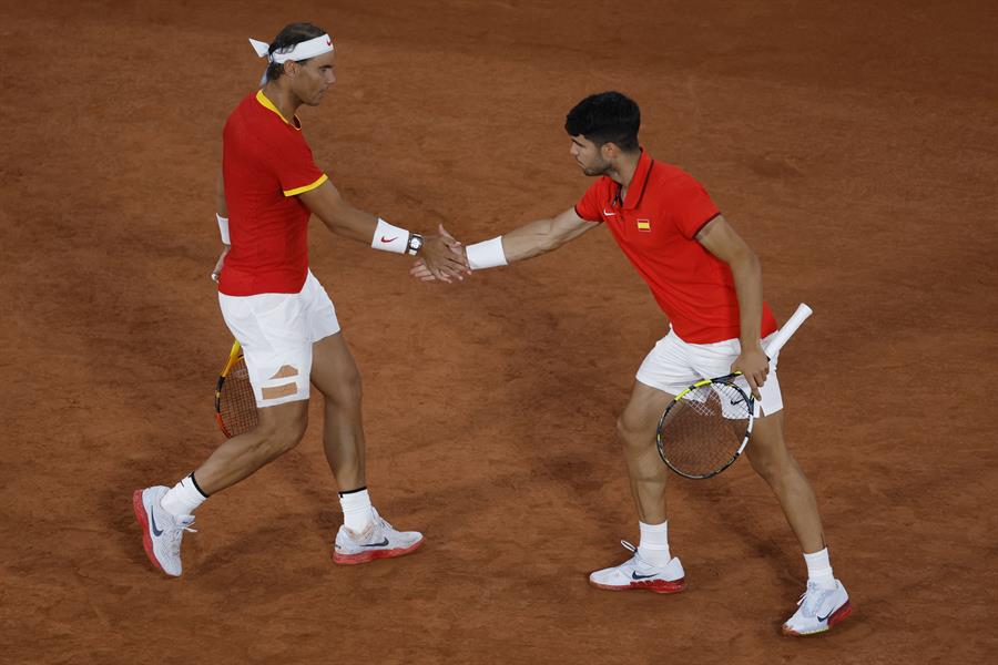 Los tenistas españoles Rafael Nadal (i) y Carlos Alcaraz durante el partido de dobles frente a los argentinos Máximo González y Andrés Molteni , correspondiente a la primera ronda de dobles masculino de tenis de los Juegos Olímpicos de París 2024 este sábado en la pista Phillipe Chatrier de París. EFE/ Juanjo Martín
