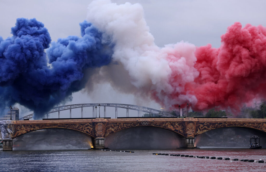  Nubes de humo en los tricolores de la bandera de Francia se ven sobre el Pont d'Austerlitz durante la ceremonia de apertura REUTERS/Amanda Perobelli