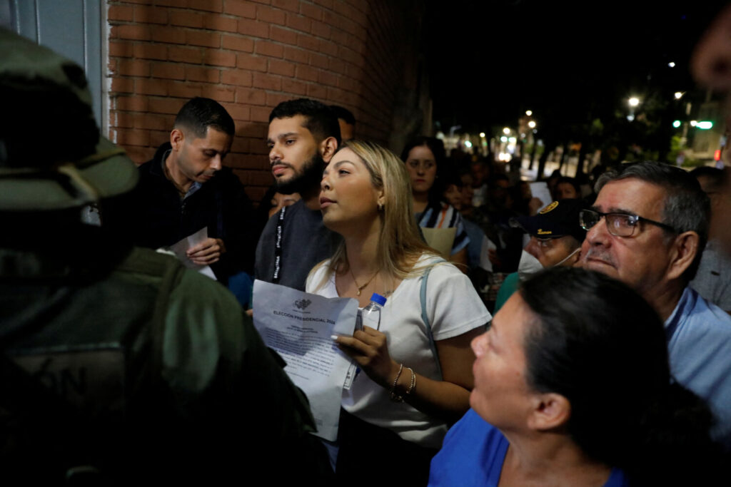 Voluntarios de los partidos de oposición y progubernamentales enfrentan la seguridad exigiendo ingresar al centro electoral Andrés Bello, en Caracas, Venezuela, 28 de julio de 2024. REUTERS/Leonardo Fernández Viloria