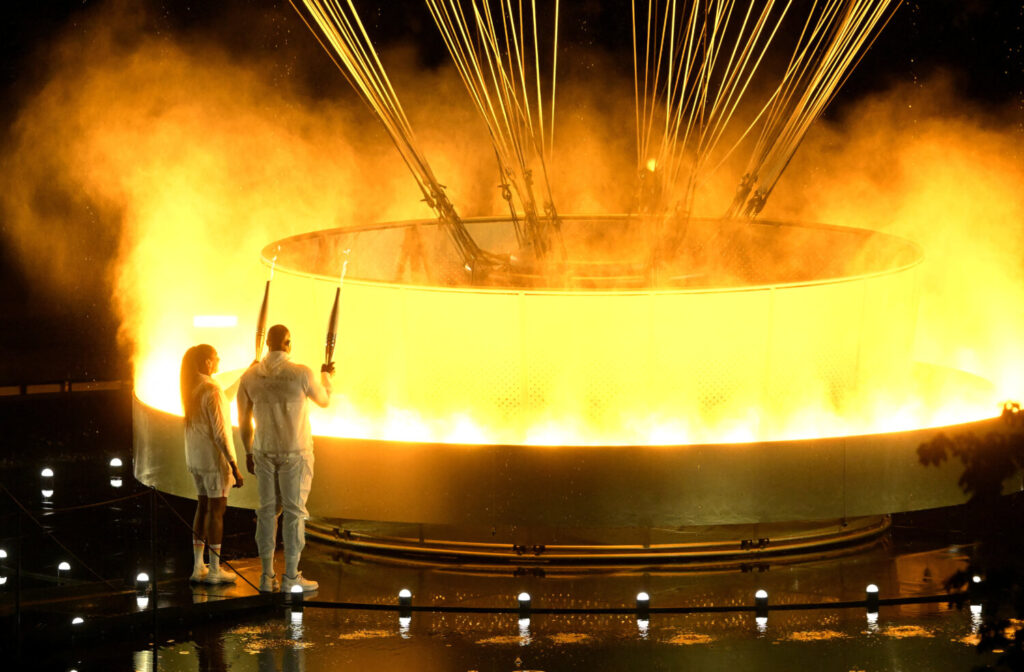 Juegos Olímpicos de París 2024 - Ceremonia de apertura - París, Francia - 26 de julio de 2024. Los portadores de antorchas Teddy Riner y Marie-José Perec iluminan el caldero olímpico durante la ceremonia de apertura de los Juegos Olímpicos de París 2024. Xia Yifang/Pool vía REUTERS