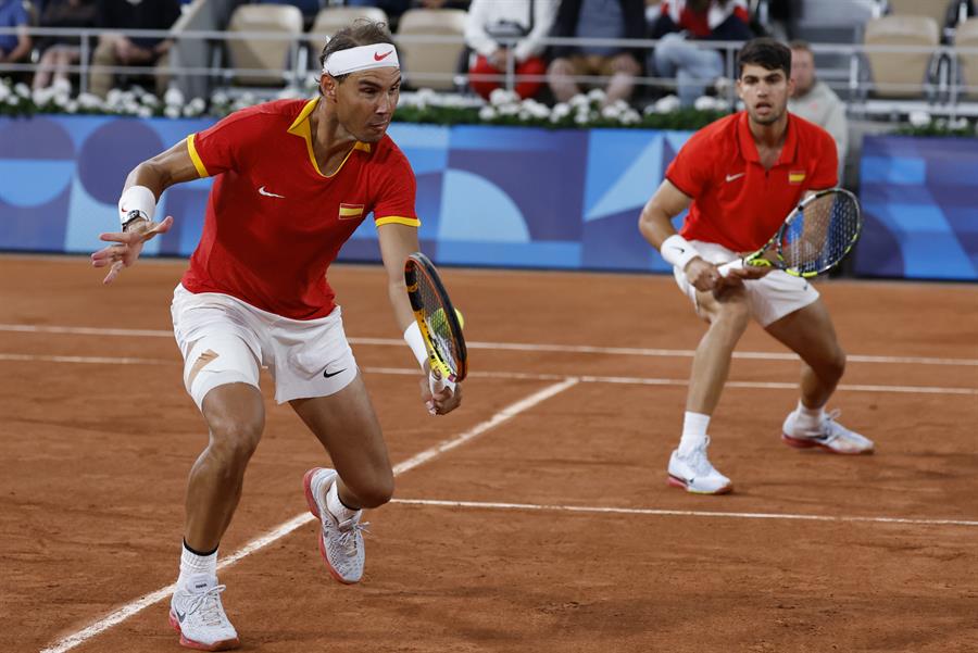 Los tenistas españoles Rafael Nadal (i) y Carlos Alcaraz durante el partido de dobles frente a los argentinos Máximo González y Andrés Molteni , correspondiente a la primera ronda de dobles masculino de tenis de los Juegos Olímpicos de París 2024 este sábado en la pista Phillipe Chatrier de París. EFE/ Juanjo Martín