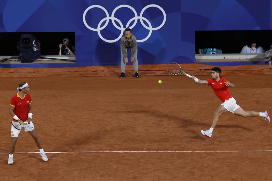 Los tenistas españoles Rafael Nadal (i) y Carlos Alcaraz durante el partido de dobles frente a los argentinos Máximo González y Andrés Molteni , correspondiente a la primera ronda de dobles masculino de tenis de los Juegos Olímpicos de París 2024 este sábado en la pista Phillipe Chatrier de París. EFE/ Juanjo Martín
