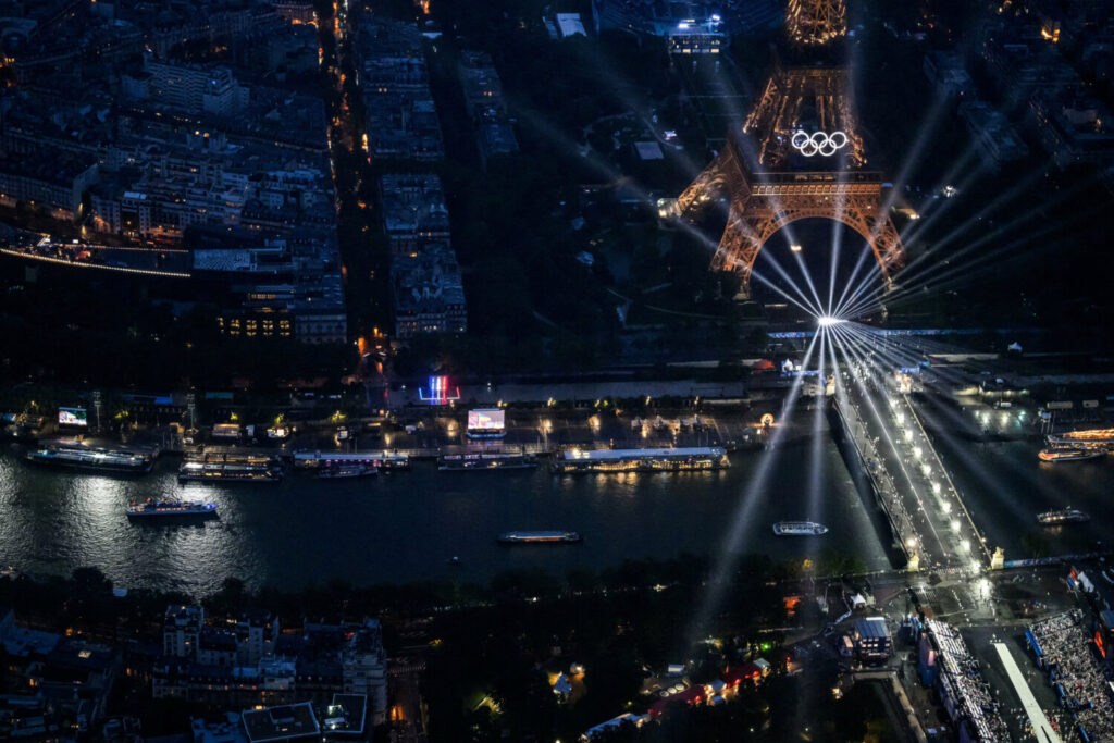  Una vista aérea de los barcos de la delegación que navegan por el río Sena cerca de la Torre Eiffel iluminada, durante la ceremonia de apertura de los Juegos Olímpicos de París 2024. LIONEL BONAVENTURE/Pool vía REUTERS