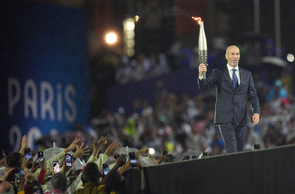 El exfutbolista Zinedine Zidane de Francia sostiene la antorcha olímpica durante la ceremonia de apertura de los Juegos Olímpicos de París 2024. Xu Chang/Pool vía REUTERS