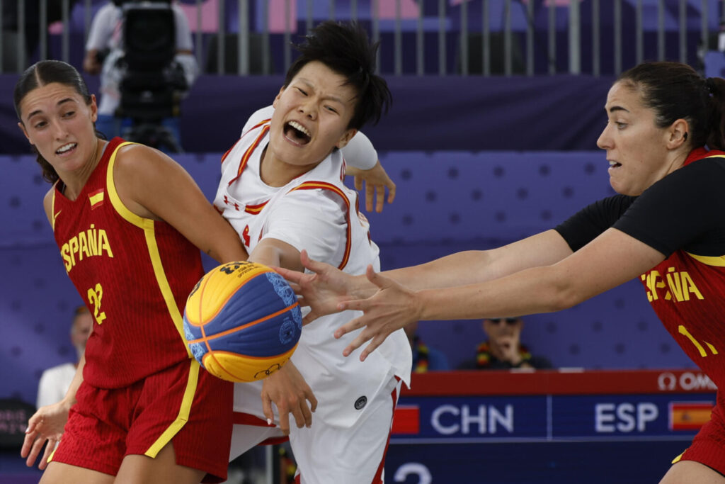 Las jugadoras de España Juan Camilion (i) y Vega Gimeno (d) luchan por el balón ante la china, Mingling Chen durante el partido de fase de grupos de Baloncesto 3x3 Femenino de los Juegos Olímpicos de París 2024, entre China y España, en la sede La Concorde de la capital francesa. EFE/ Julio Muñoz