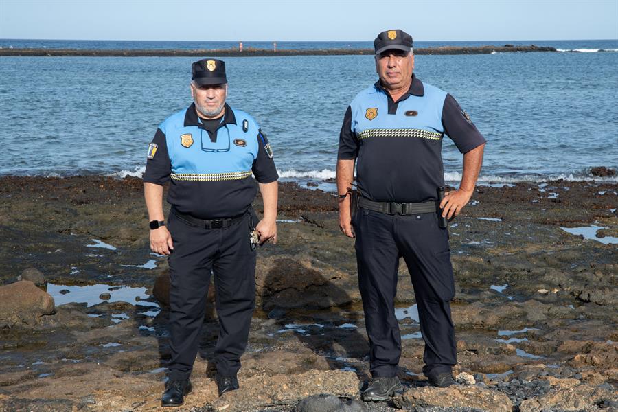 Comienzo de la Ruta Canaria. Los policías locales de Antigua (Fuerteventura) Juan Francisco de Vera (i) y José Ángel Suárez (d) posan en el lugar donde arribó la primera patera que llegó a Canarias, el 28 de agosto de 1994. Ellos asistieron a sus dos ocupantes, dos hombres saharauis. EFE/Carlos de Saa