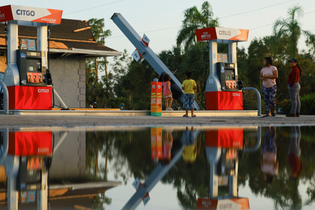 Vecinos de Lakewood Park, Florida, observando la estructura doblada de una gasolinera.