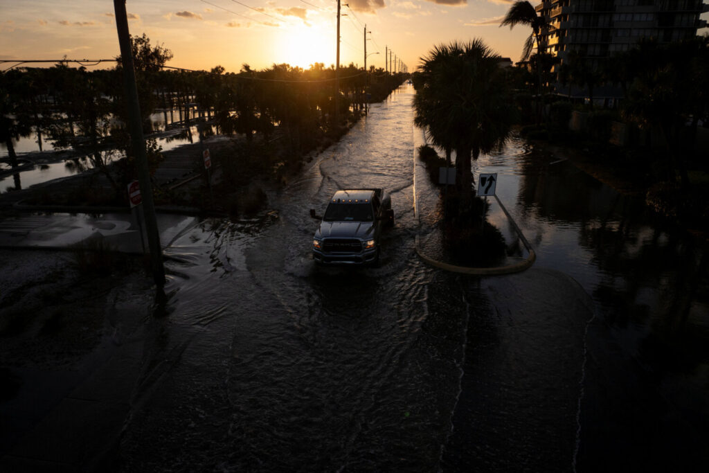 Un vehículo transita por las anegadas calles de Siesta Key, Florida.