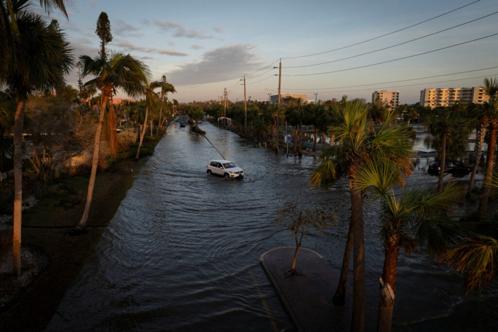 Un dron muestra un coche circulando por una calle inundada tras el paso del huracán Milton en Siesta Key, Florida.