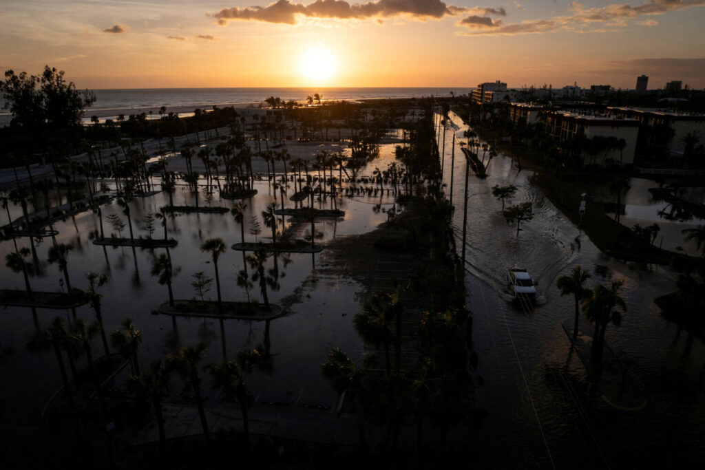 Una camioneta circula por una calle inundada tras el paso del huracán Milton por Siesta Key, Florida.