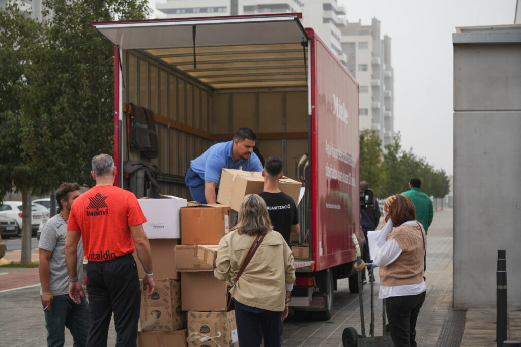 Varias personas llevan cajas con mantas, ropas y objetos de primera necesidad para las personas que se encuentran en el pabellón de baloncesto, 'La Fonteta', a 30 de octubre de 2024, en Valencia, Comunidad Valenciana (España). Decenas de personas se encuentran habilitadas en este polideportivo después de que estuvieran atrapados en la pista de Silla (Valencia).  Jorge Gil / Europa Press 