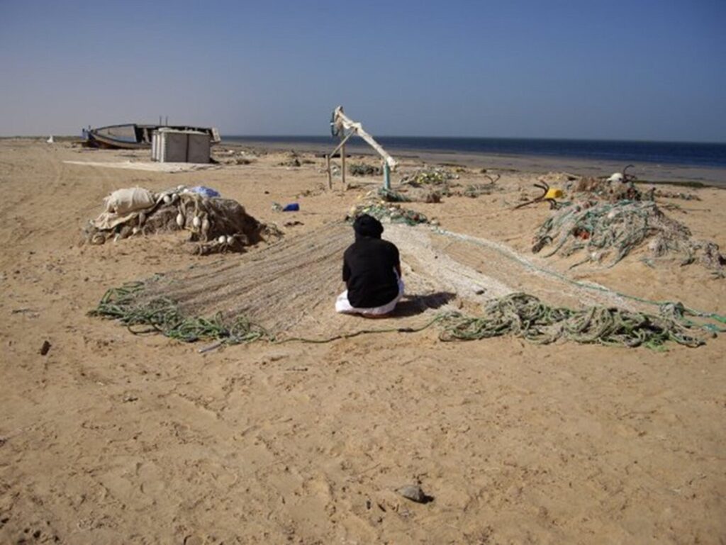 Pescador de la comunidad Imbraguen preparando aparejos de pesca en la costa mauritana.