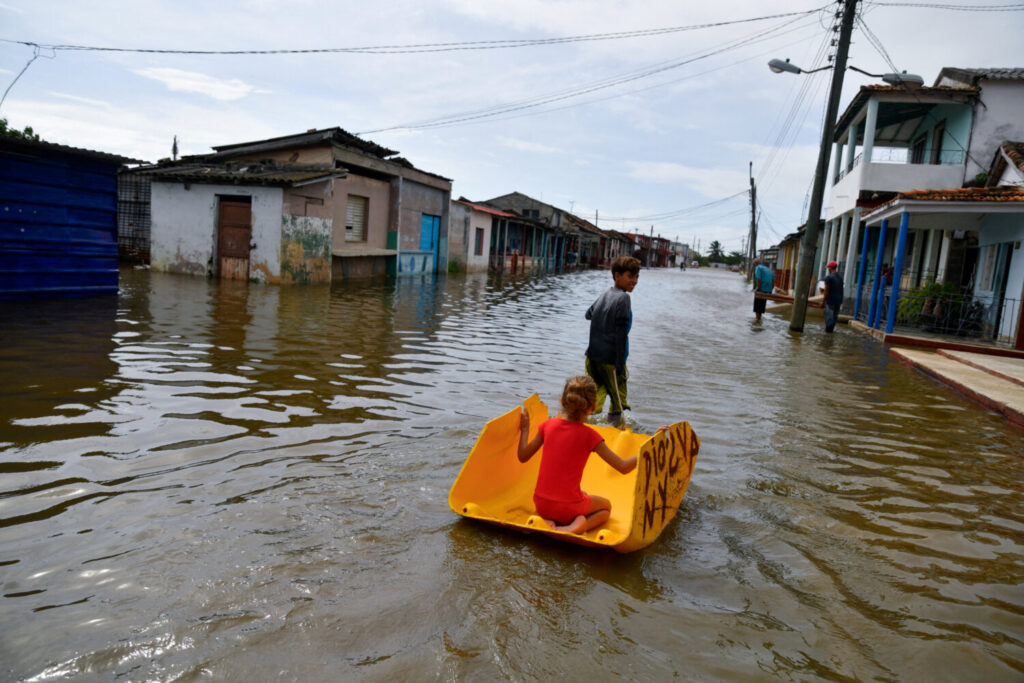 Los niños juegan en una calle inundada mientras el huracán Milton pasa cerca de la costa cubana, en Batabano, Cuba, 9 de octubre de 2024. REUTERS/Norlys Pérez 