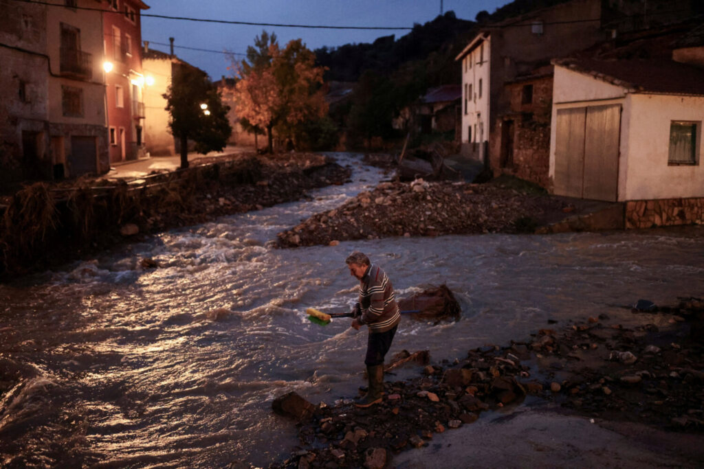 Miguel, de 69 años, lava sus escobas en el Río Seco (Río Seco) después de limpiar su casa, en medio de inundaciones causadas por fuertes lluvias, en la Hoz de la Vieja, provincia de Teruel, España, 30 de octubre de 2024. REUTERS/Nacho Doce 