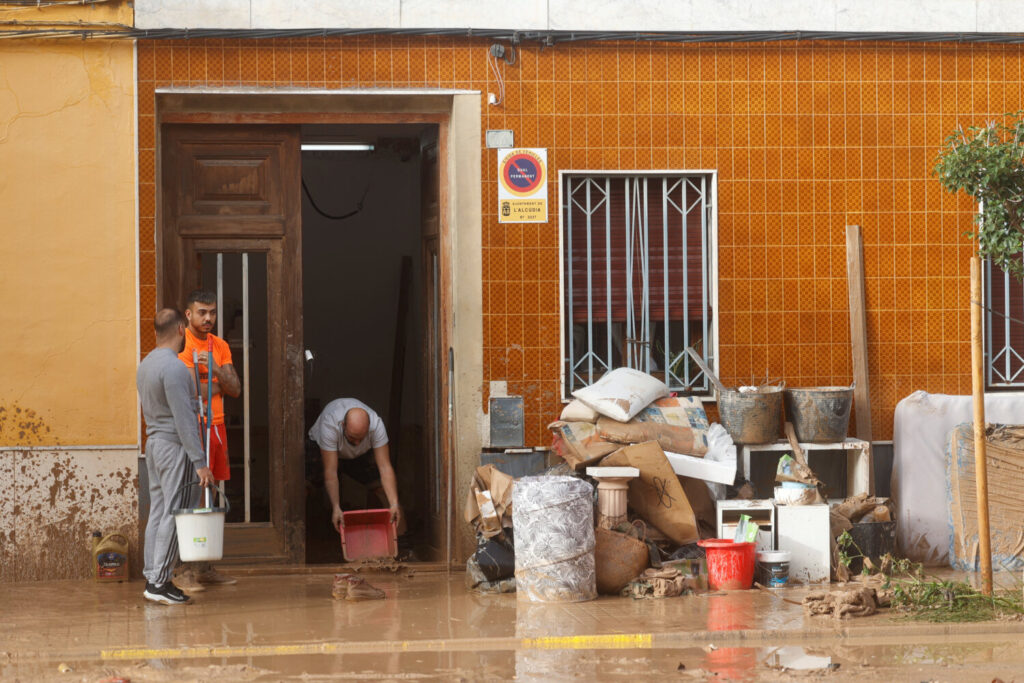 La gente se reúne para una limpieza junto a los artículos dañados a lo largo de una calle cubierta de barro después de que las lluvias torrenciales causaran inundaciones en la Alcudia, región de Valencia, España, el 30 de octubre de 2024. REUTERS/Eva Manez