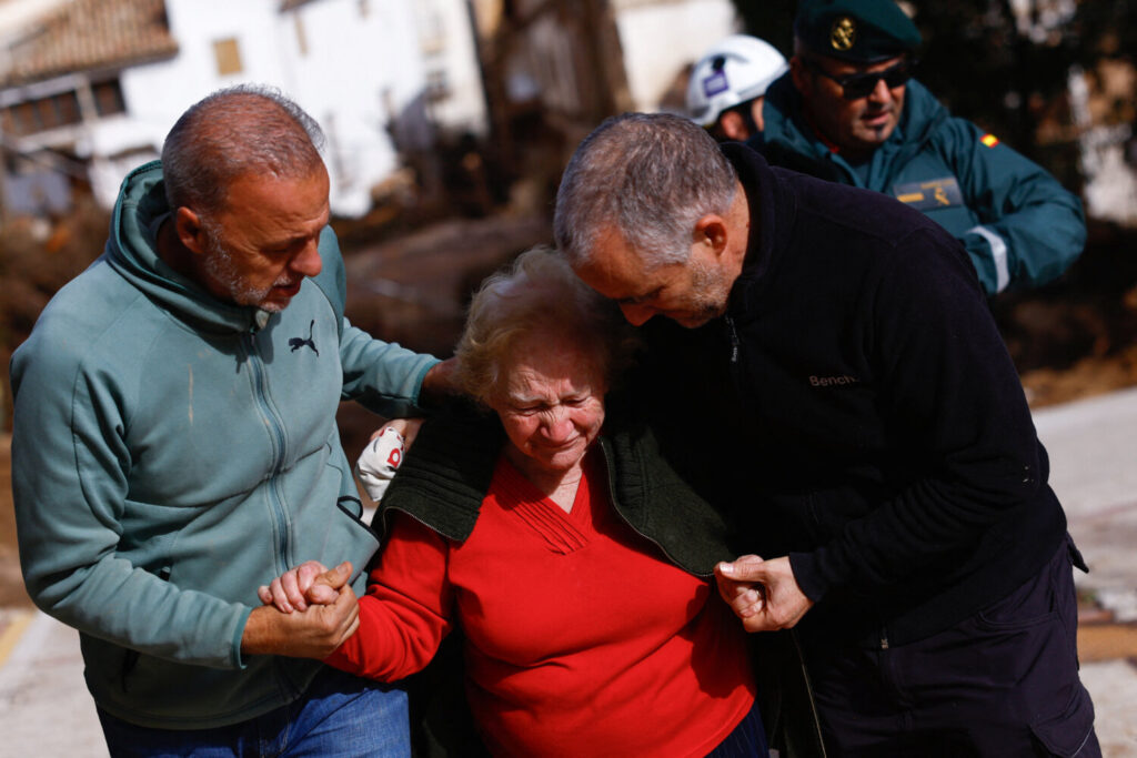 Encarna Rivero, de 88 años, reacciona cuando es recibida por su hijo y su sobrino después de quedar aislada en la casa de un vecino, después de que las fuertes lluvias provocaron inundaciones, en Letur, España / REUTERS / Susana Vera