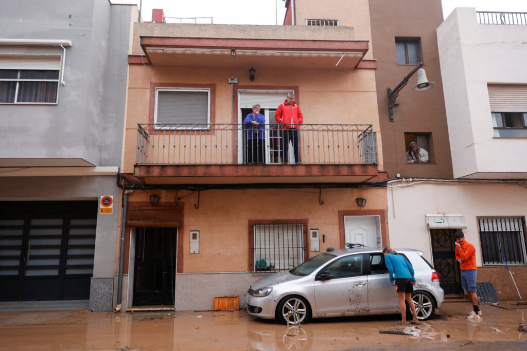 La gente inspecciona un coche dañado en una calle cubierta de barro después de que las lluvias torrenciales causaran inundaciones en la Alcudia, región de Valencia, España, el 30 de octubre de 2024. REUTERS/Eva Manez