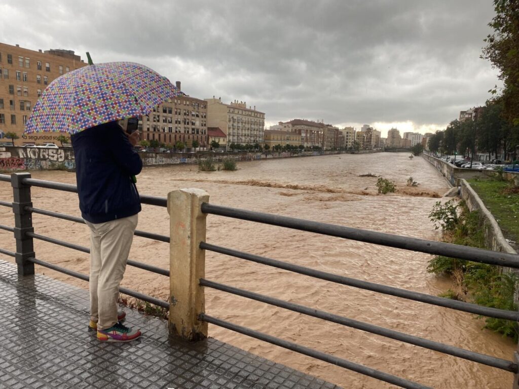 Un hombre observa el aspecto que presenta el río Guadalmedina a su paso por Málaga este miércoles en el que las fuertes lluvias y granizo que se registran están causando inundaciones y acumulación de grandes balsas en algunas de las principales avenidas de todos los distritos de la ciudad/EFE