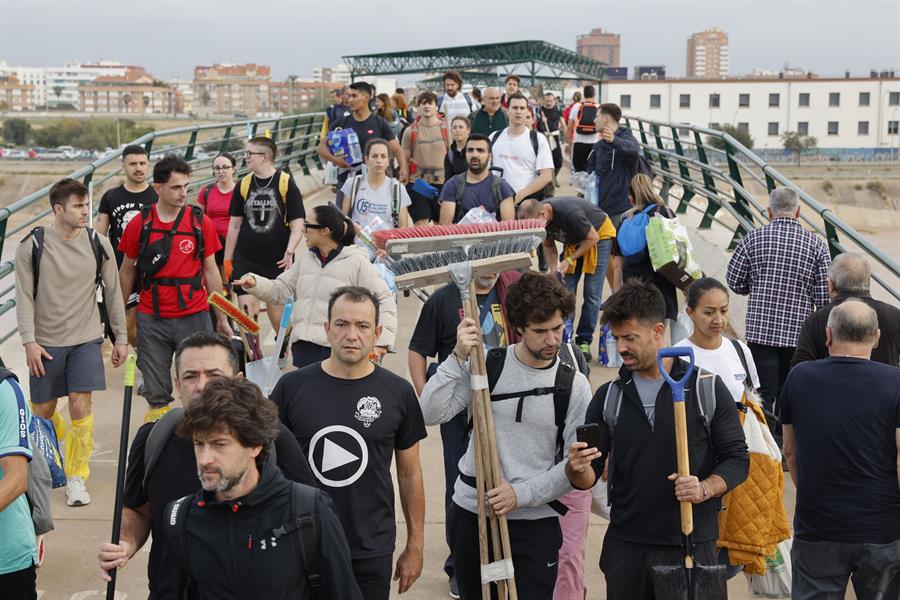 Miles de personas se desplazan desde Valencia a La Torre para ayudar a los afectados por las inundaciones causadas por la DANA, este viernes. La búsqueda de desaparecidos, la identificación de víctimas mortales, las tareas de limpieza y la reparación de infraestructuras continúan tres días después de las inundaciones que han asolado la provincia de Valencia, en una jornada en la que el Gobierno envía a 500 militares más, que se sumarán a las 1.200 efectivos de la Unidad Militar de Emergencias (UME), para actuar en Utiel, Requena, Riba-roja, Torrent, Paiporta y Algemesí. EFE/Ana Escobar