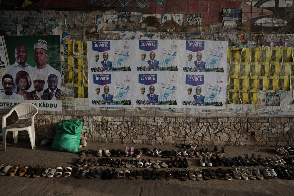 Los calzados se exhiben a la venta bajo carteles de campaña de las coaliciones Samm Sa Kaddu (Keep Its Word) y Senegaal Kese (sólo Senegal). Carteles para las próximas elecciones legislativas anticipadas en Dakar, Senegal / REUTERS / Zohra Bensemra