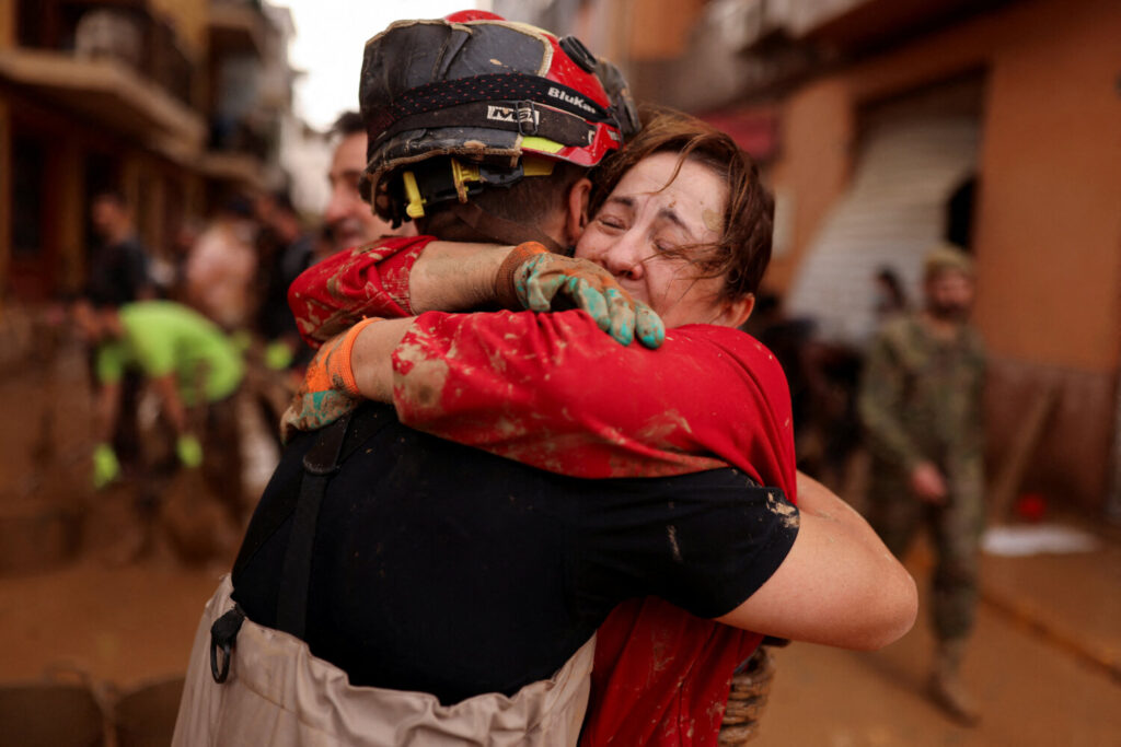 Un miembro de la Unidad Militar de emergencia (UME) de España se abraza con una mujer tras las inundaciones causadas por fuertes lluvias, en Sedavi, cerca de Valencia, España, el 3 de noviembre de 2024. REUTERS/Nacho Doce 
