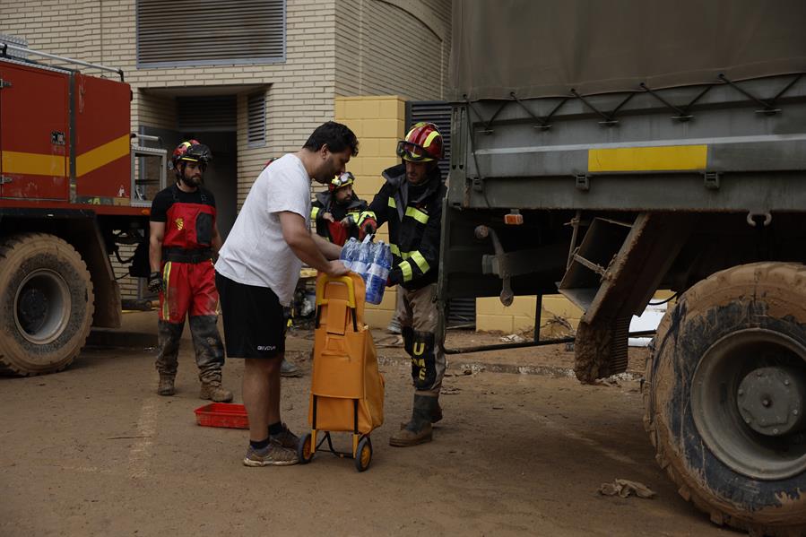 Efectivos de la UME reparten agua a los vecinos de Paiporta, este viernes. La búsqueda de desaparecidos, la identificación de víctimas mortales, las tareas de limpieza y la reparación de infraestructuras continúan tres días después de las inundaciones que han asolado la provincia de Valencia, en una jornada en la que el Gobierno envía a 500 militares más, que se sumarán a las 1.200 efectivos de la Unidad Militar de Emergencias (UME), para actuar en Utiel, Requena, Riba-roja, Torrent, Paiporta y Algemesí. EFE/ Biel Aliño