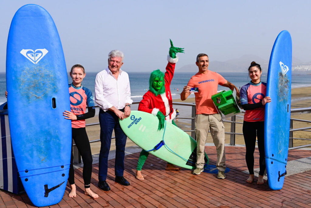 El Grinch de la Navidad surfea Las Canteras con espíritu solidario. Pedro Quevedo, concejal de Turismo y Ciudad del Mar, junto al gerente de Ocean Side, Sergio Álvarez presentando la iniciativa del Grinch Solidario/ LPA Visit.