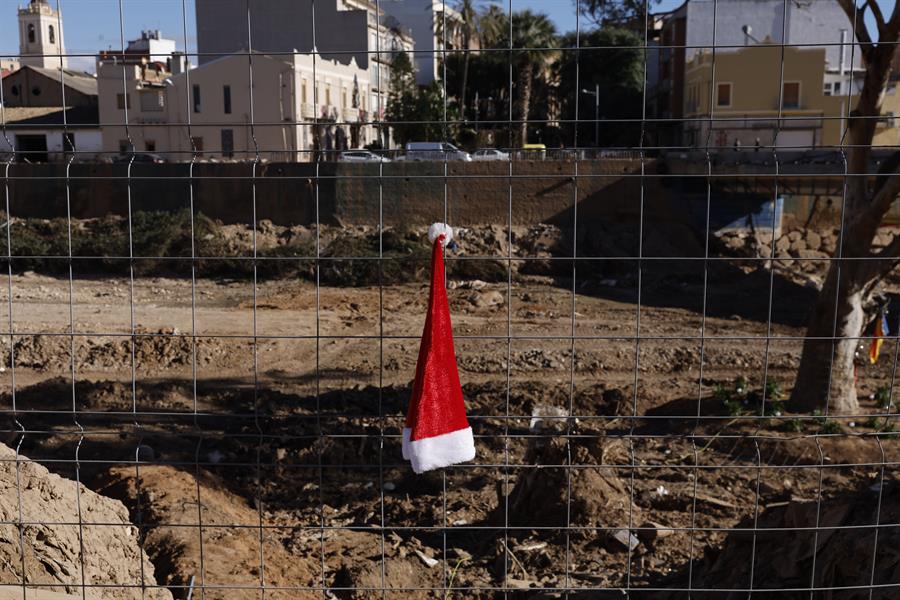 Un gorro de Papa Noel cuelga de una valla en el Barranco del Poyo en Paiporta, el día de Navidad. EFE/ Kai Försterling