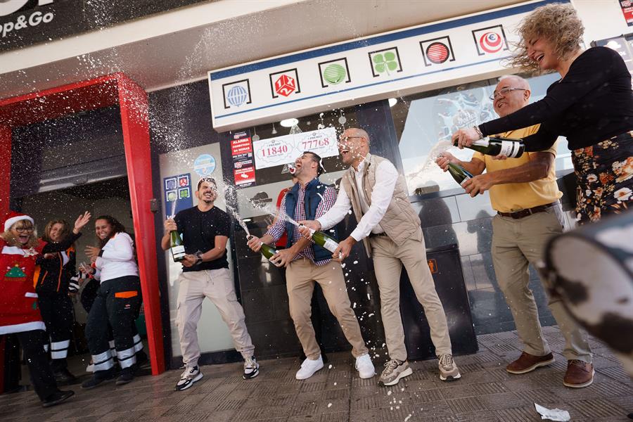 Empleados y propietarios de la gasolinera La Chasnera en el km 54 de la autopista TF-1 del municipio de Granadilla de Abona (Tenerife) celebran que varios números vendidos en este establecimiento han sido agraciados con un tercero, dos cuartos y un quinto premio en el sorteo extraordinario de Navidad de la Lotería Nacional. EFE/Ramón de la Rocha