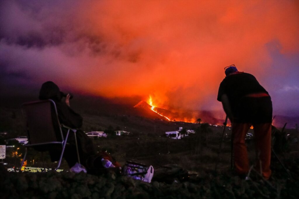 Vecinos y turistas observan el cono del volcán de Tajogaite tras la explosión de su cráter, producida el 25 de septiembre de 2021, en La Palma