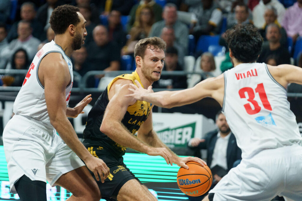 91-99 | La Laguna Tenerife empieza con buen pie ante el Pallacanestro Reggiana. El ala-pívot del Laguna Tenerife, Tim Abromaitis (c) ante el escolta del Pallacanestro Reggiana, Michele Vitali (d) durante el partido de baloncesto de la Liga de Campeones que se celebra este martes en el pabellón Santiago Martín de La Laguna (Tenerife). EFE/Ramón de la Rocha