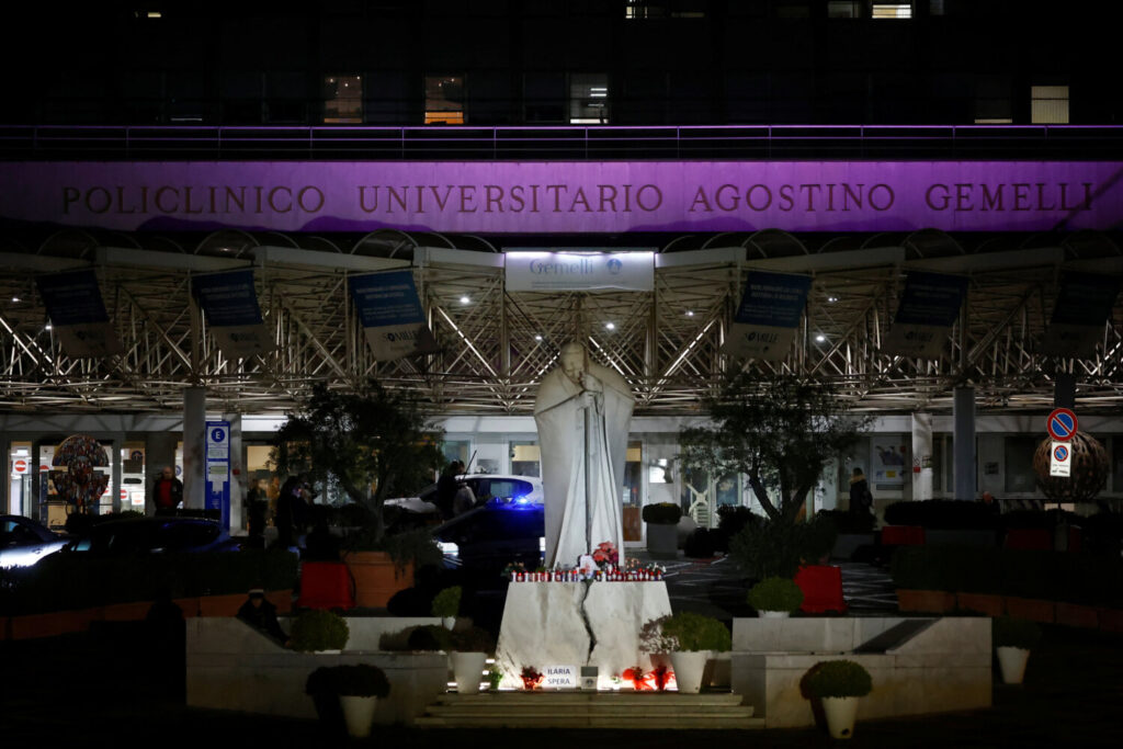 El papa Francisco en estado crítico tras una crisis respiratoria. Velas decoradas, flores y fotos del Papa Francisco se colocan en la base de la estatua del difunto Papa Juan Pablo II frente al Hospital Gemelli, donde el Papa Francisco está ingresado para recibir tratamiento, en Roma, Italia, 22 de febrero de 2025. REUTERS/Vincenzo Livieri