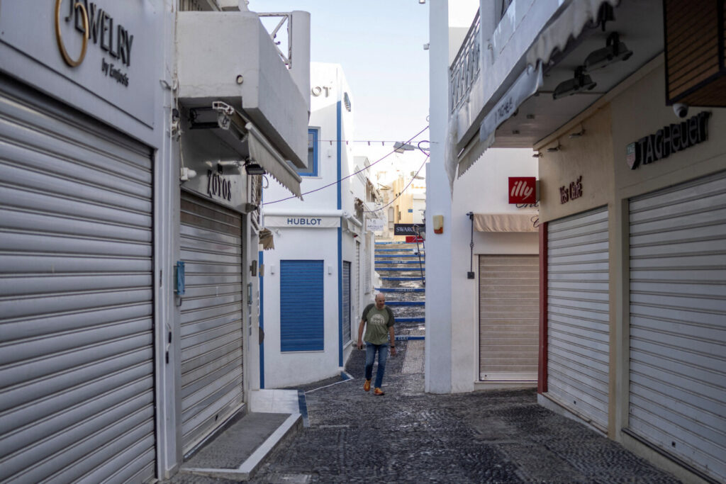 Un hombre camina entre calles vacías de Santorini y con muchos comercios cerrados, la mayoría lo están por ser fuera de la temporada turística / REUTERS/Alkis Konstantinidis