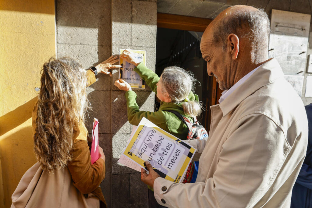 La Sareb paraliza el desahucio de 8 familias en Las Palmas de Gran Canaria. LAS PALMAS DE GRAN CANARIA (ESPAÑA), 13/03/2025.- A las 10:15 horas, hora local, se confirmaba la noticia de que un juez, a petición de la Sociedad de Gestión de Activos Procedentes de la Reestructuración Bancaria (Sareb), paralizaba el desahucio previsto para este jueves de ocho familias vulnerables en el edificio 'Victoria' de la calle Nicolás Estévanez, de Las Palmas de Gran Canaria. En la imagen, miembros del colectivo Derecho al Techo colocan carteles sobre la situación de las familias, acompañados por la abogada Isabel Saavedra (i). EFE/Elvira Urquijo A.