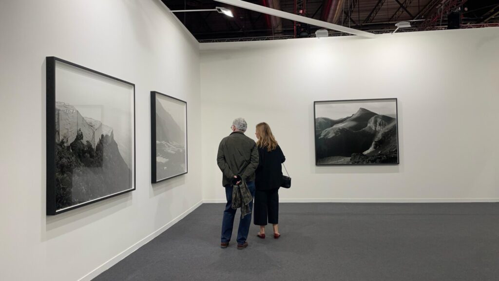 Público asistente a ARCO 2025 observando algunas de las fotografías que forman parte de 'TERRAFORMS'