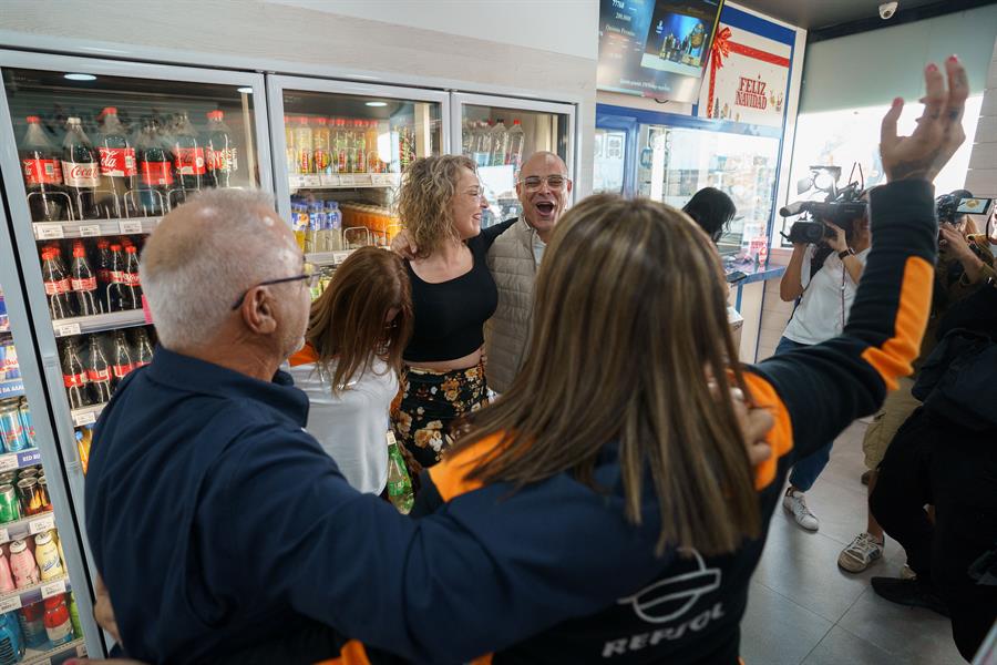 Propietarios y empleados de la gasolinera La Chasnera en el km 54 de la autopista TF-1 del municipio de Granadilla de Abona en Tenerife celebran otro premios más, el cuarto premio del sorteo extraordinario de Navidad de la Lotería Nacional que recayó en el número 77768. EFE/Ramón de la Rocha